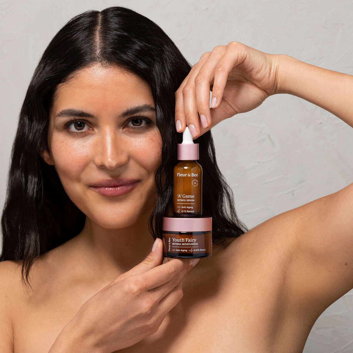 woman holding a retinol serum and retinol moisturizer