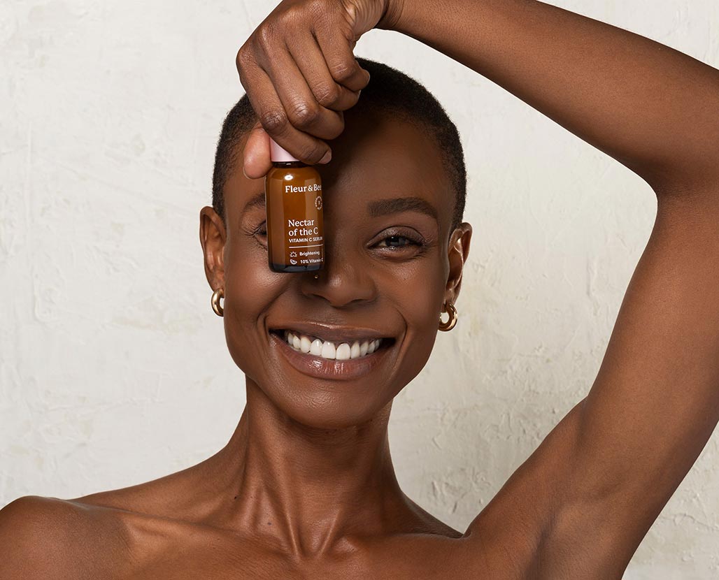 woman holding up a brightening serum