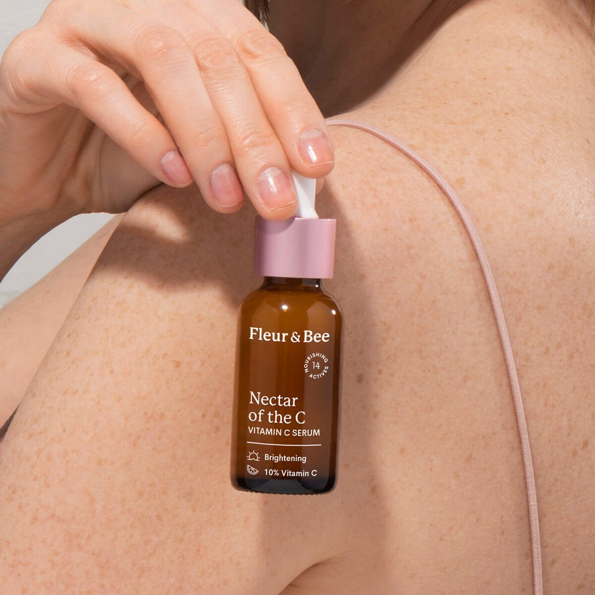 Hand holding a bottle of vitamin C serum