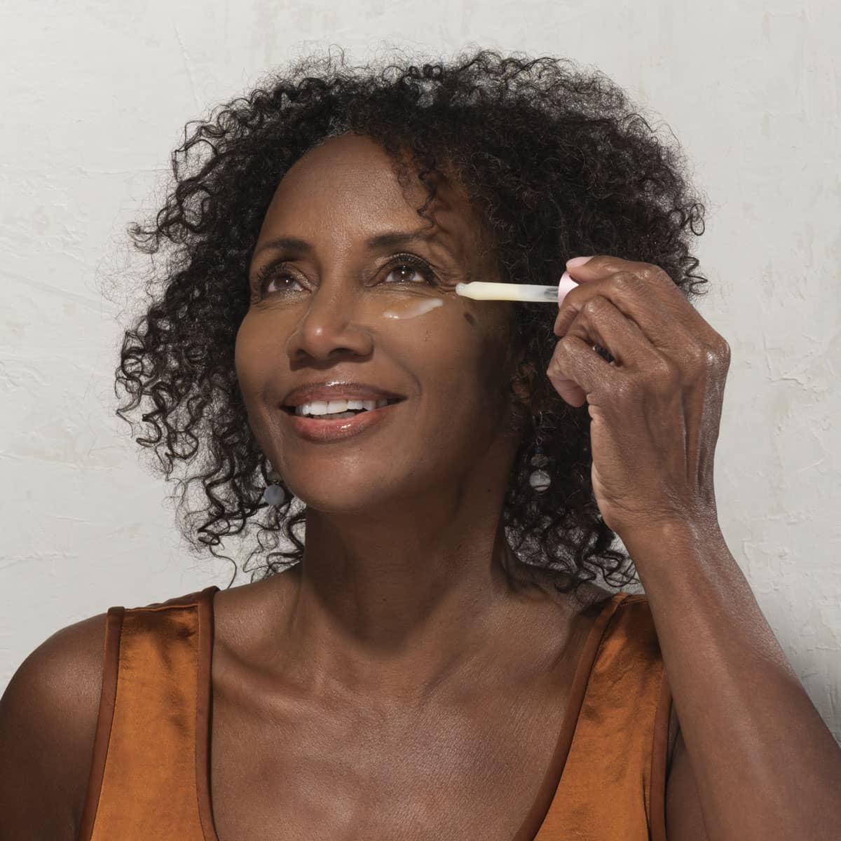 woman applying a retinol face serum